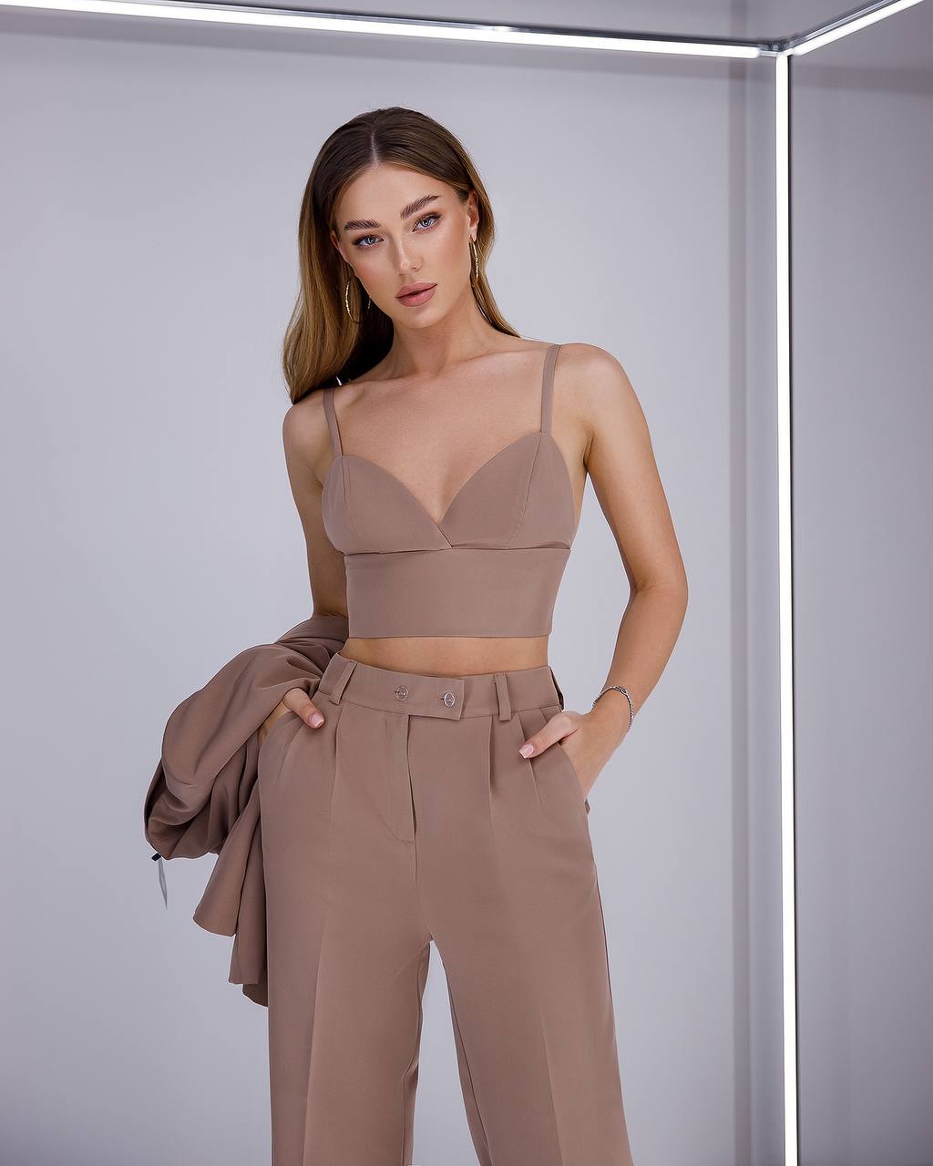 Woman wearing a brown outfit with a plain background