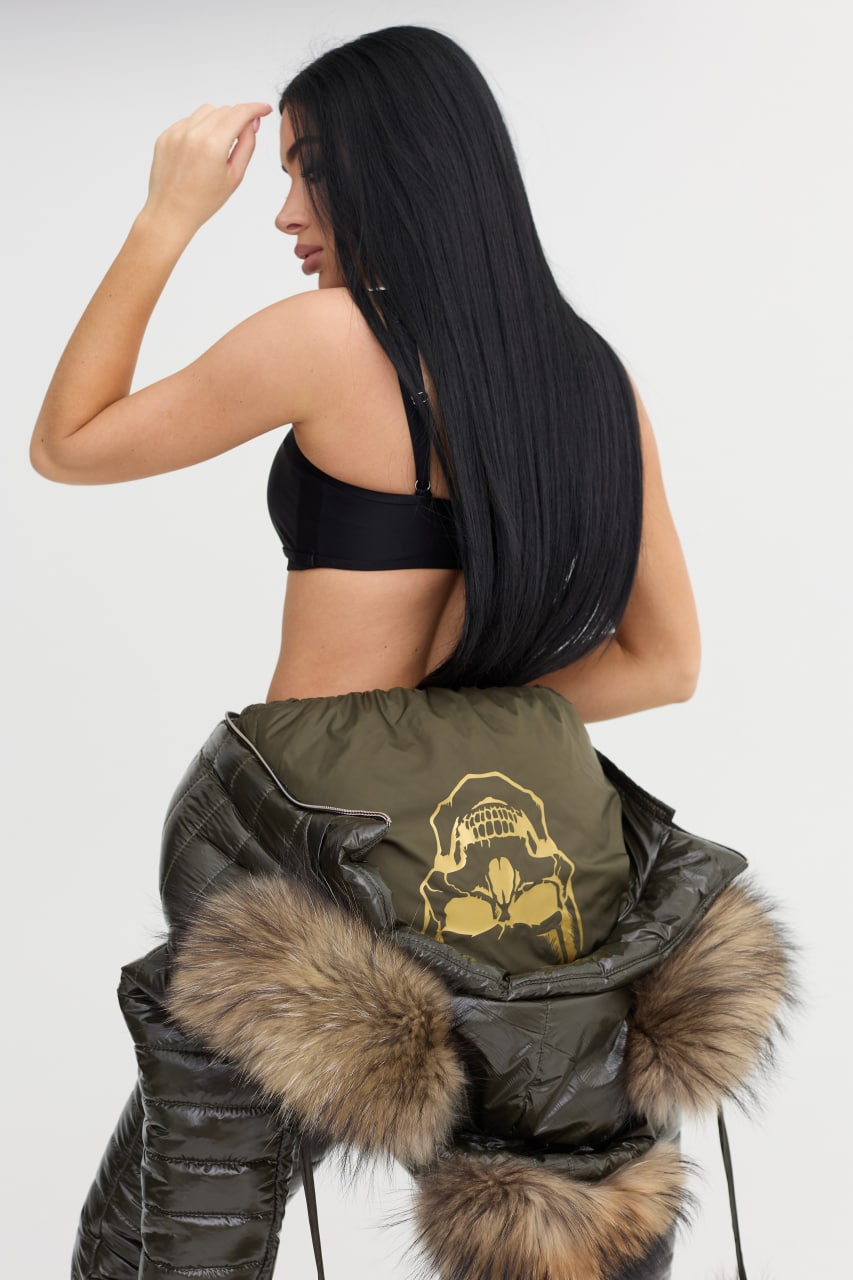 Woman wearing a green jacket with fur trim and a logo on a white background