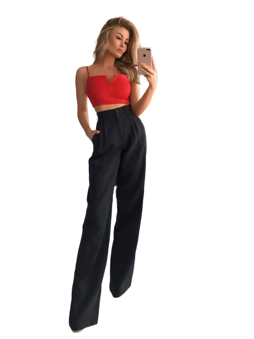 Woman taking a selfie wearing a red top and black high-waisted pants on a white background