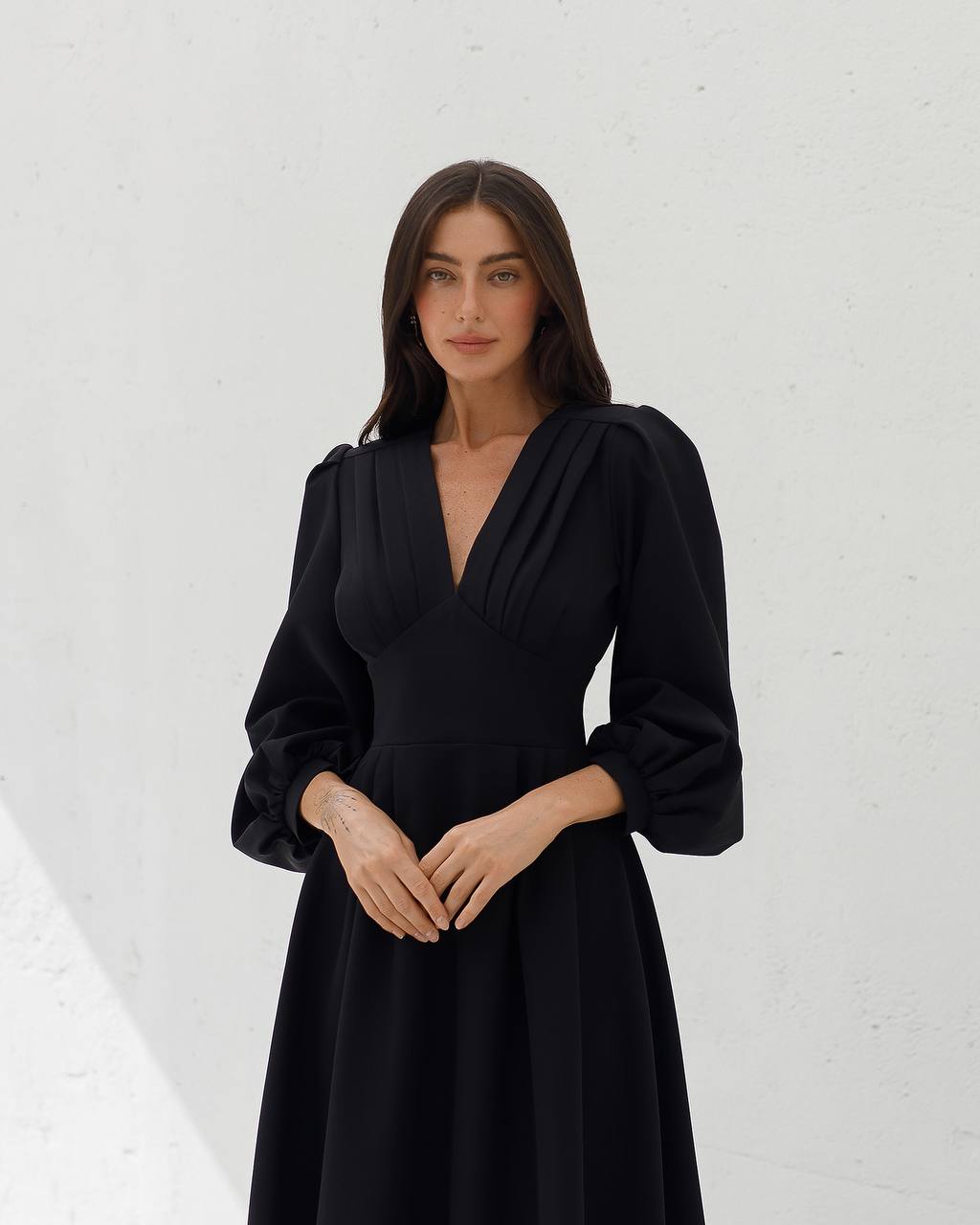Woman wearing a black dress against a white background