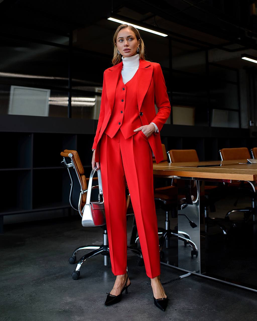Woman in a red suit standing in an office setting