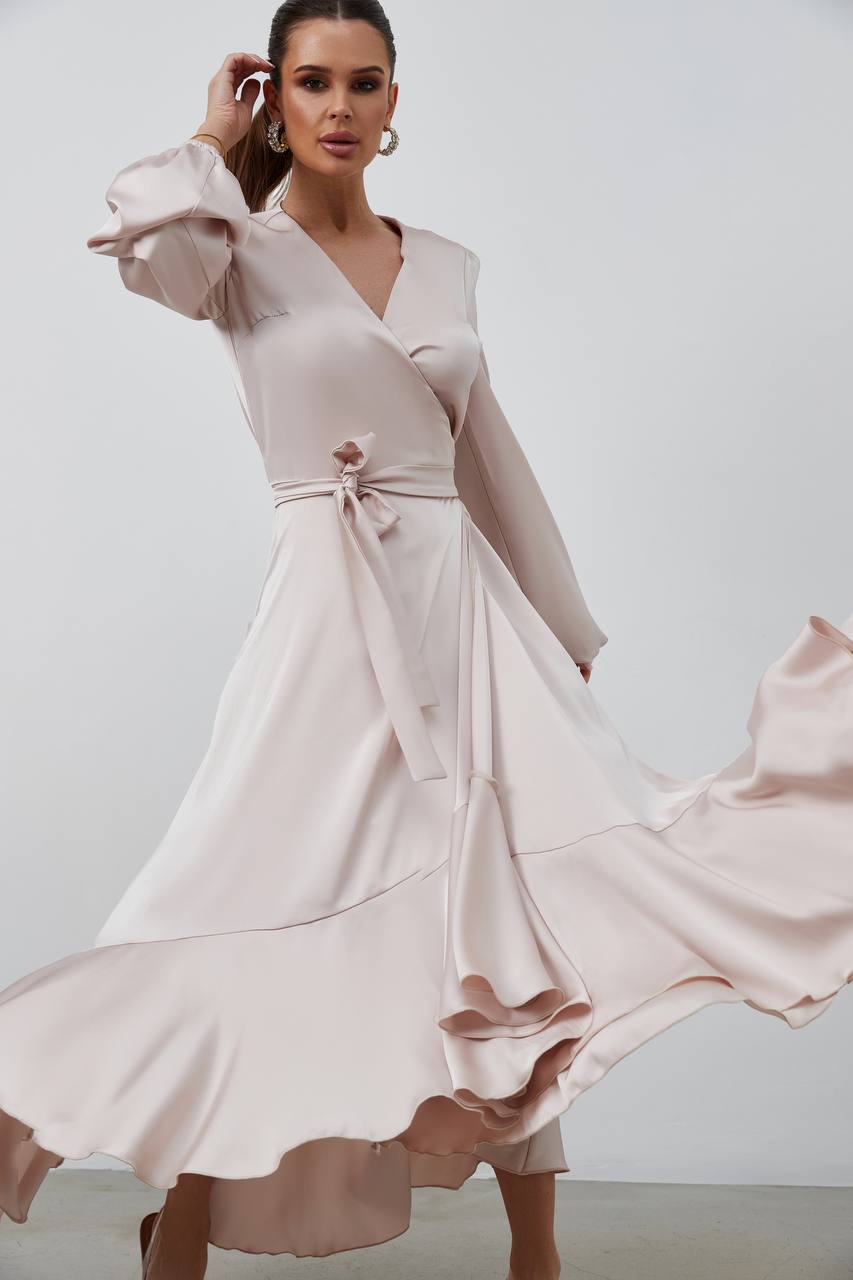 Woman wearing a light pink dress with a plain background