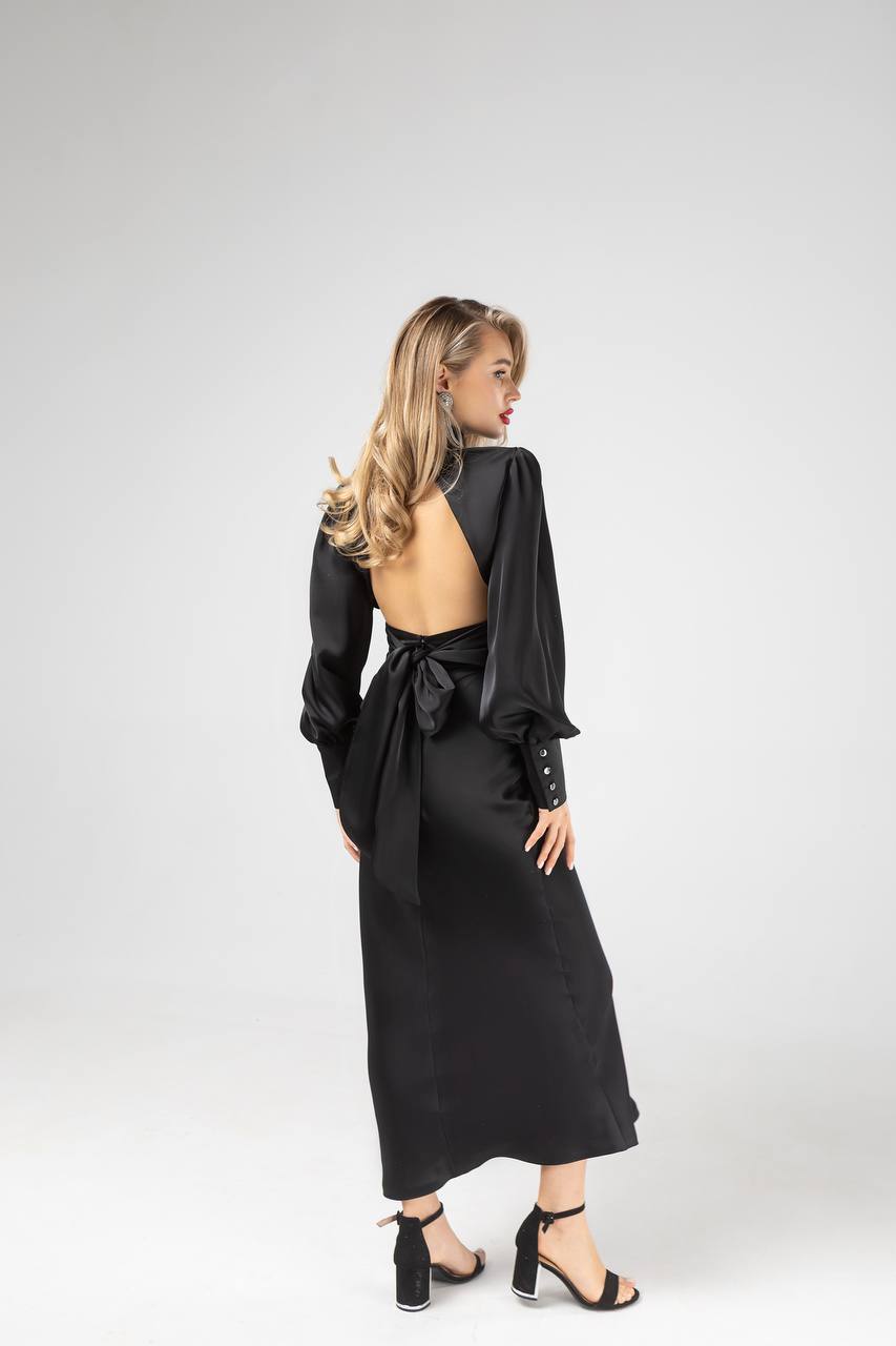 Woman wearing a black dress with a backless design on a white background