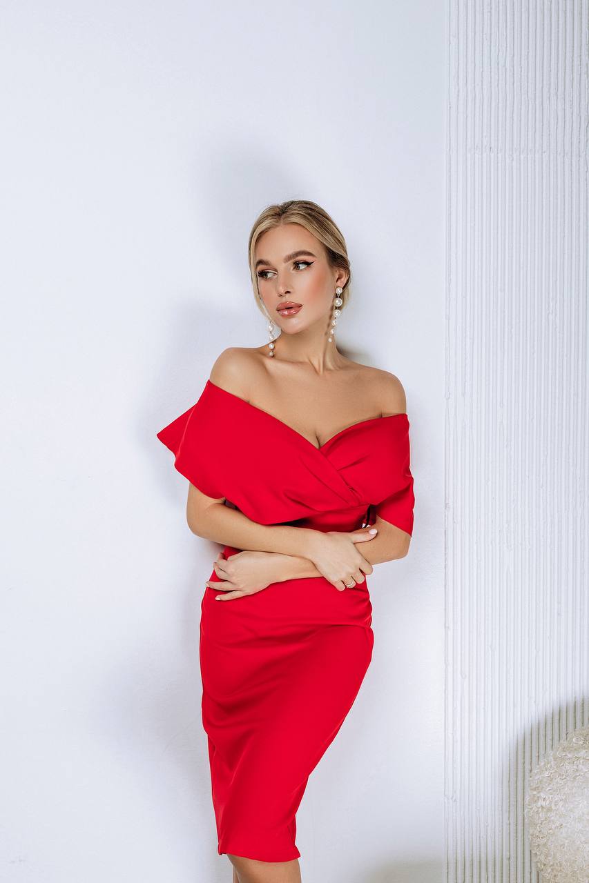 Woman wearing a red off-shoulder dress against a white background