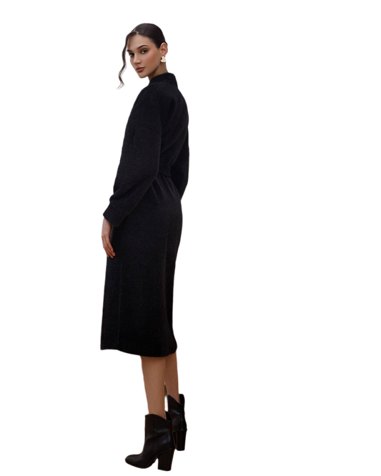 Woman wearing a black dress with long sleeves on a white background