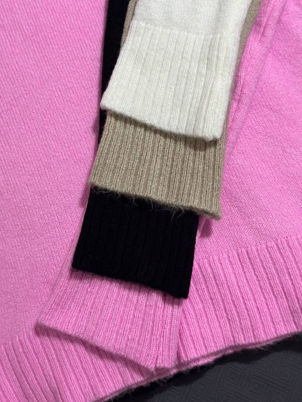 Close-up of a pink sweater with a label and visible fabric texture.