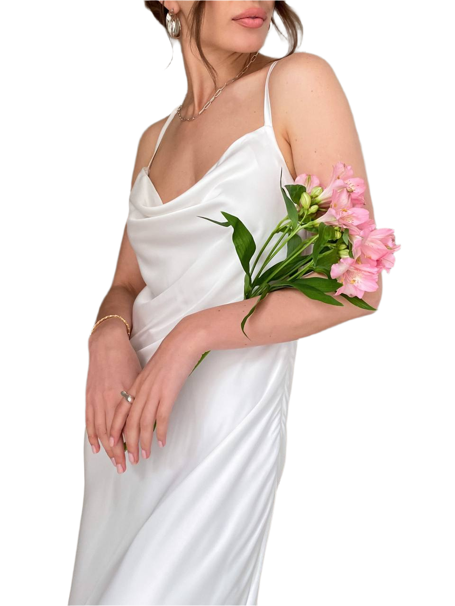 Woman in a white dress holding pink flowers against a white background