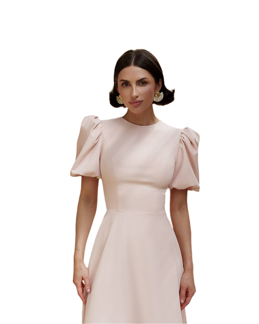 Woman wearing a light pink dress with puffed sleeves on a white background