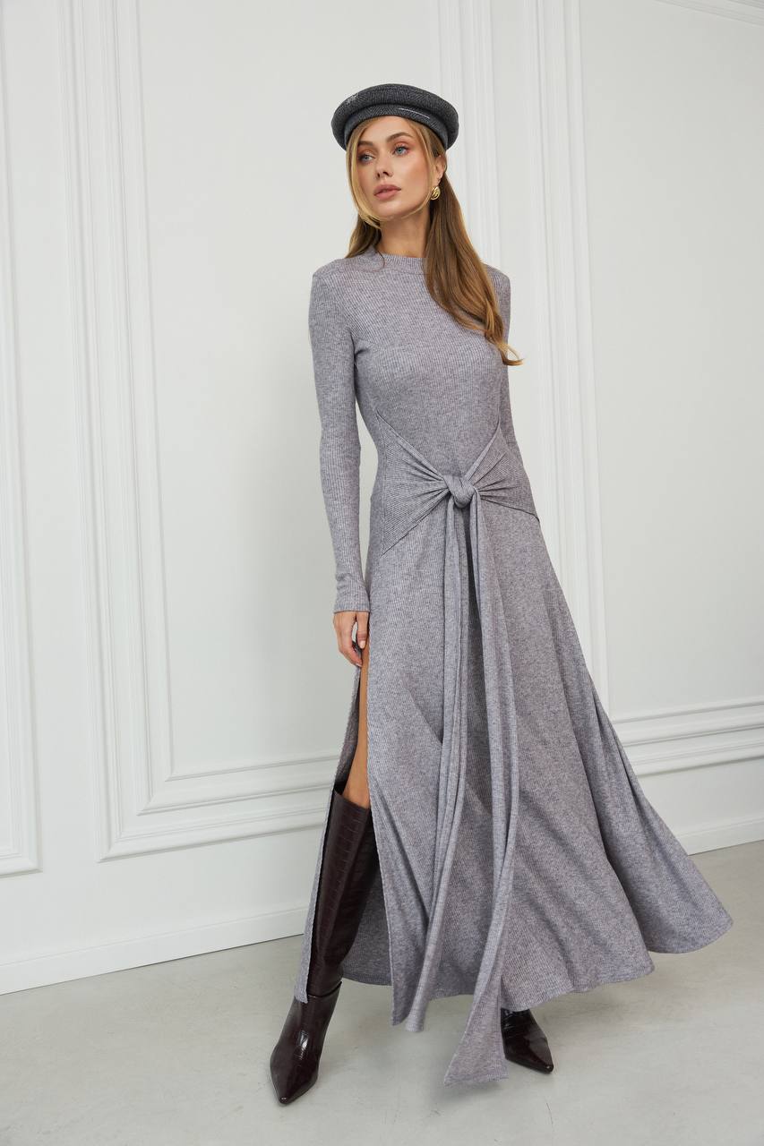 Woman wearing a long gray dress with a knot detail in a minimalistic setting