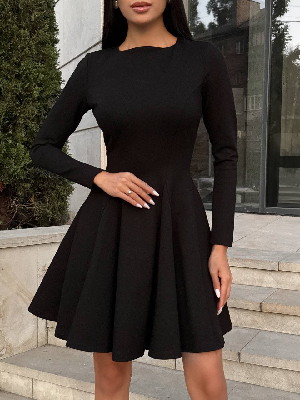 Woman wearing a black dress standing outdoors.