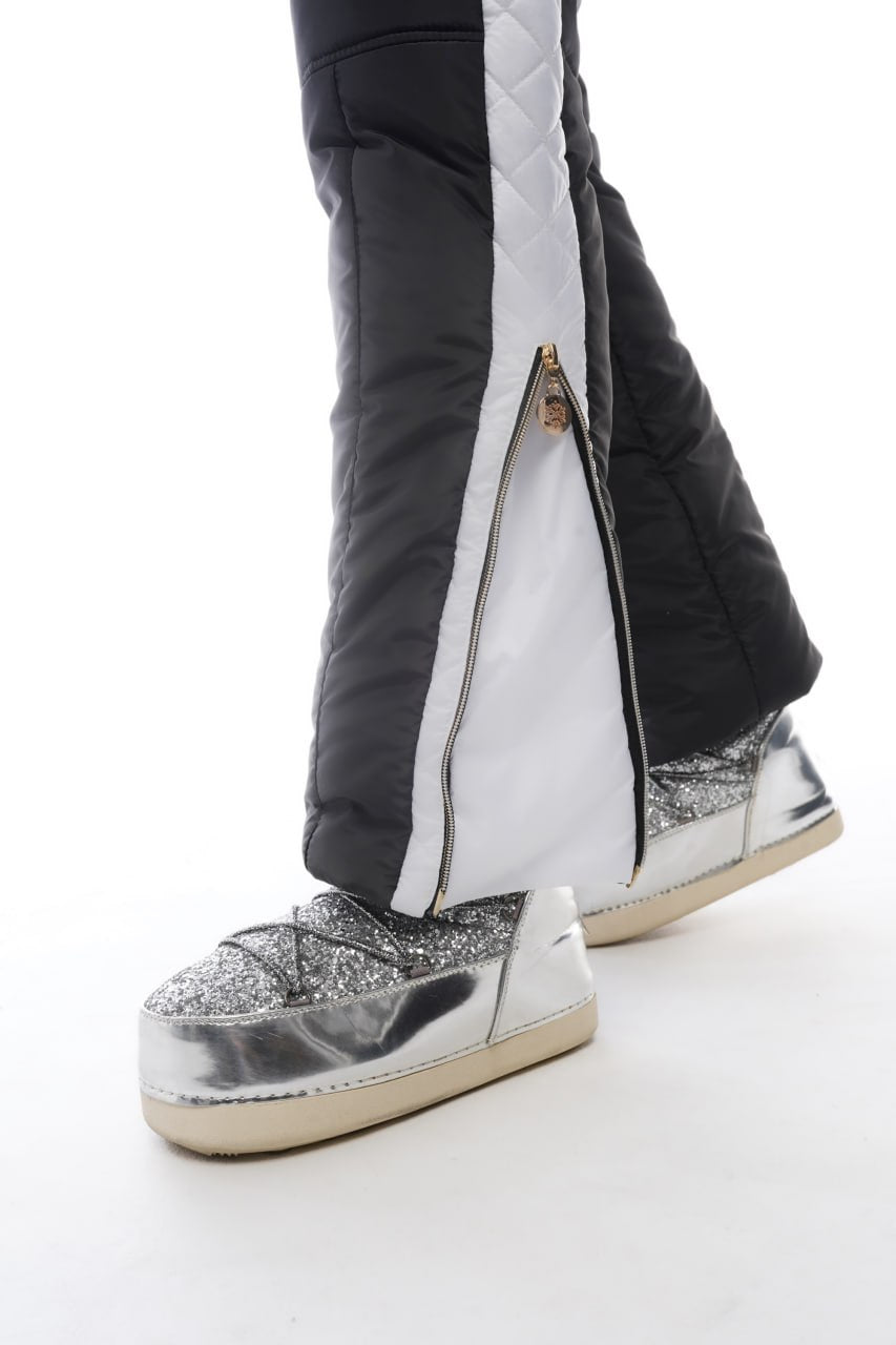 Silver glittery boots worn with black and white pants on a white background