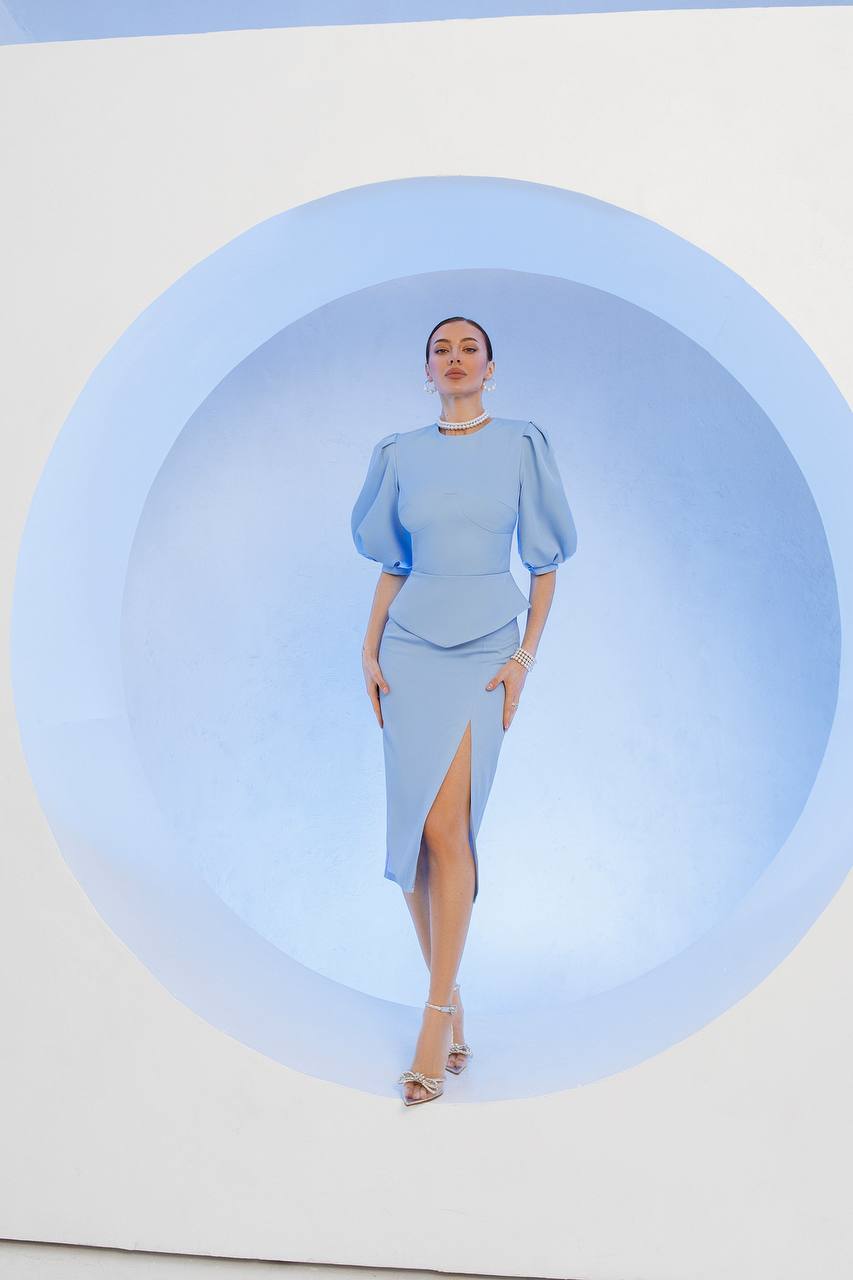 Woman wearing a light blue dress with a circular blue light effect in the background