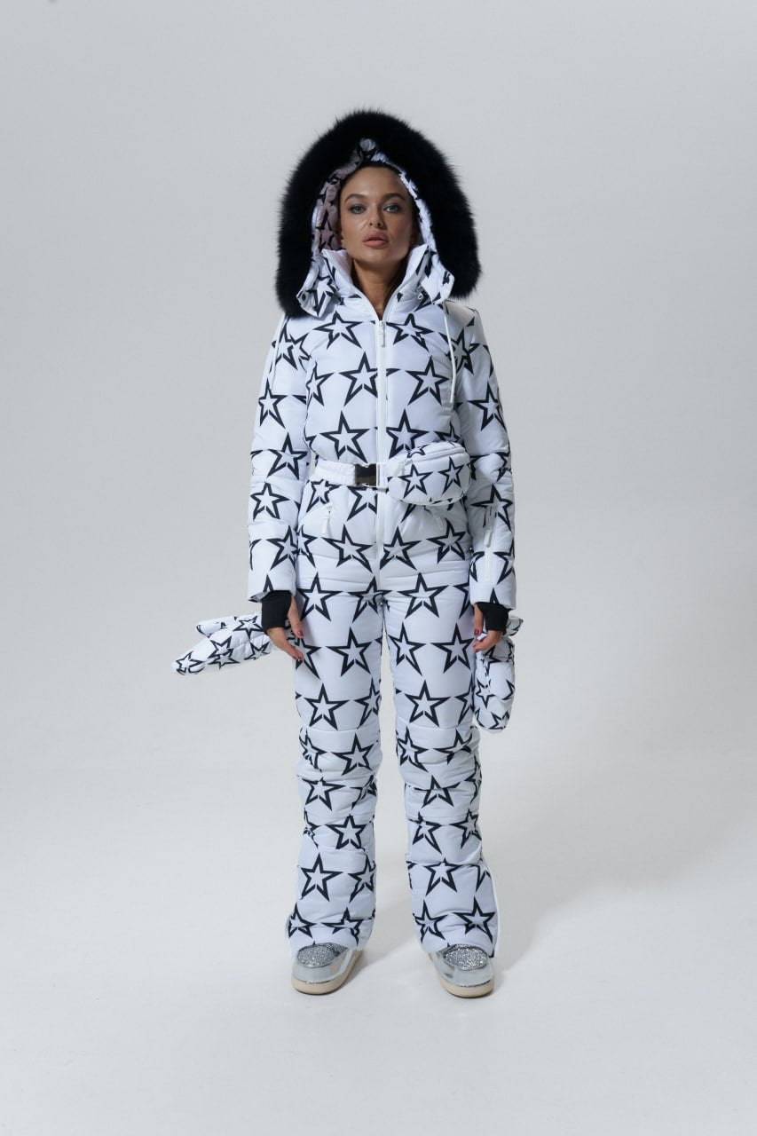 Person wearing a black and white star-patterned onesie on a plain background