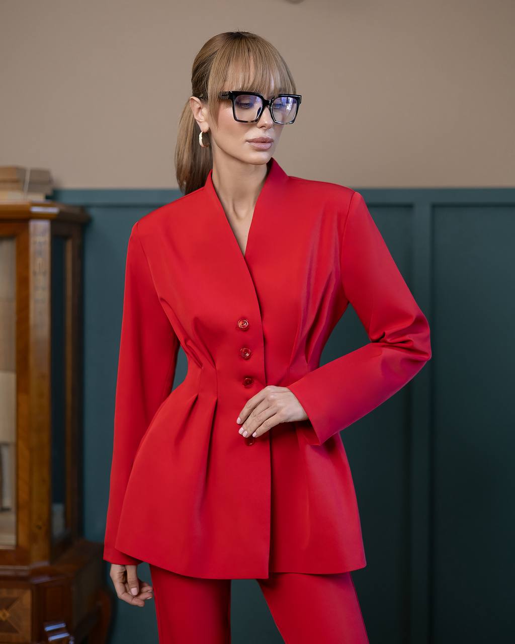 Woman wearing a red suit with a plain background