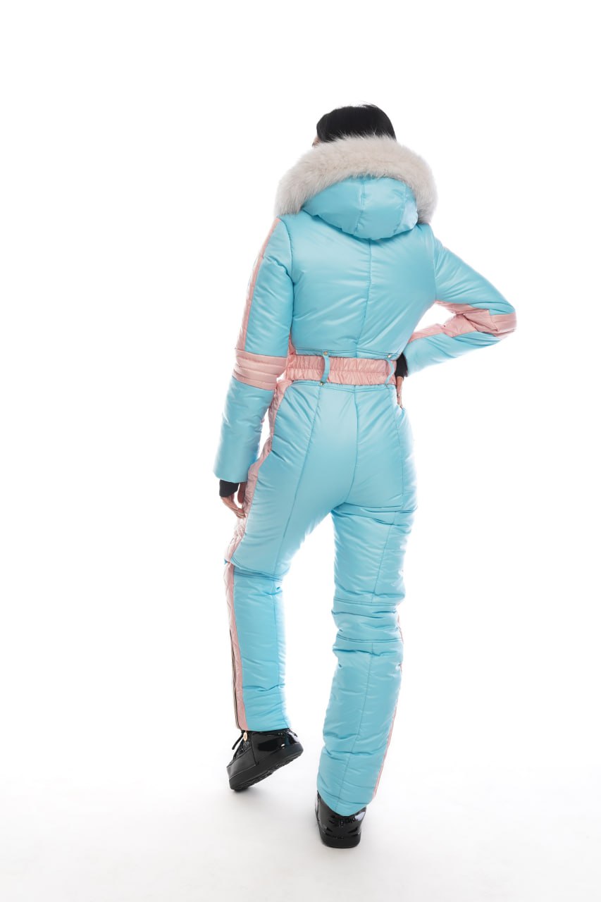 Person wearing a light blue snowsuit with pink accents on a white background
