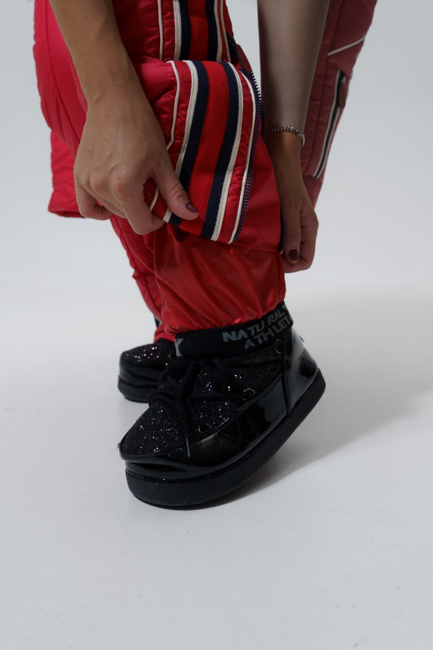 Person wearing red pants and black platform shoes on a white background