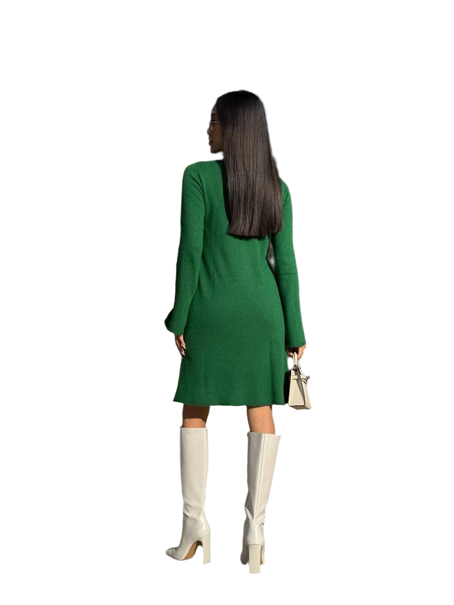 Woman wearing a green dress and white knee-high boots on a white background
