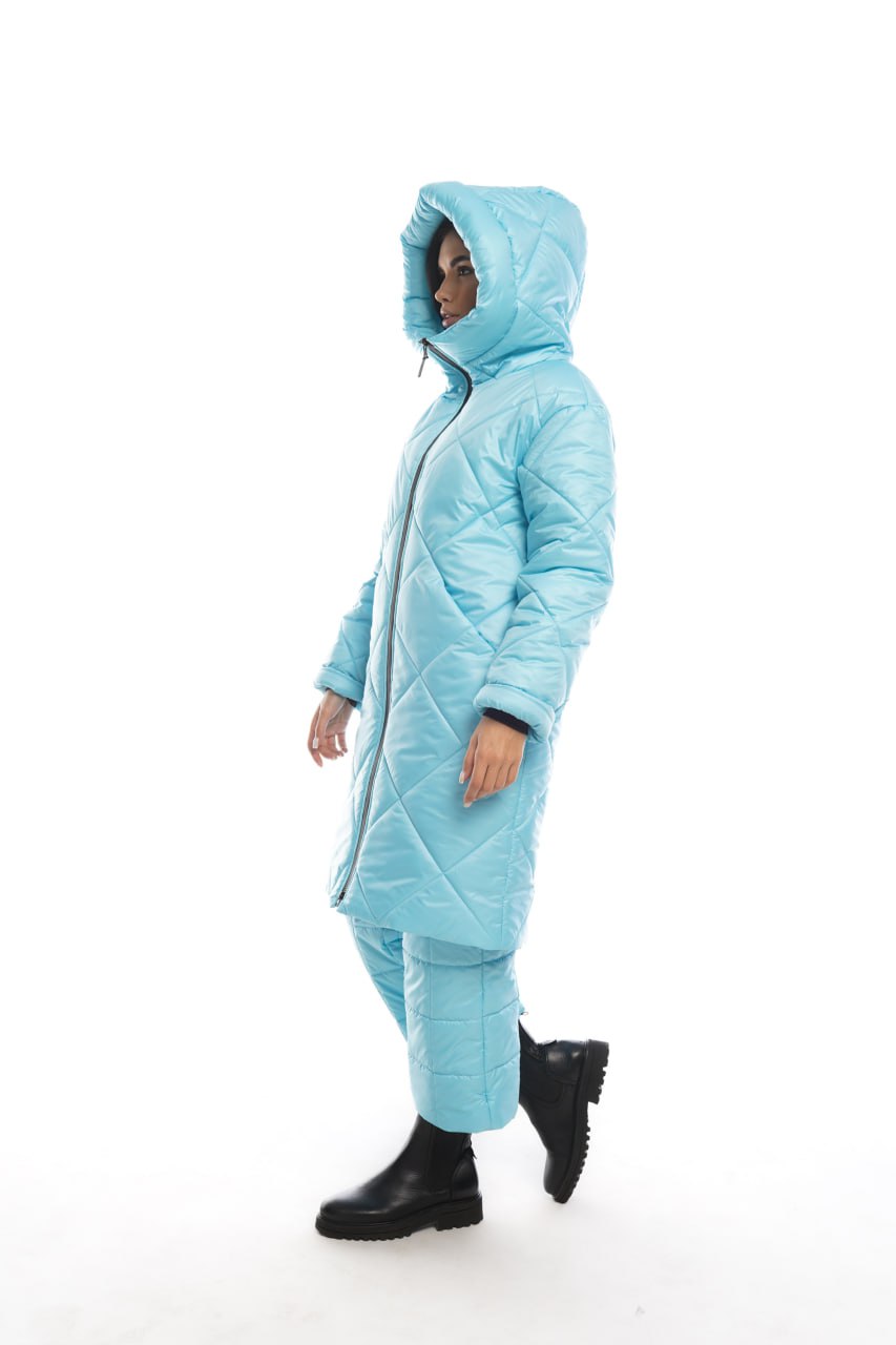 Person wearing a light blue quilted jumpsuit on a white background