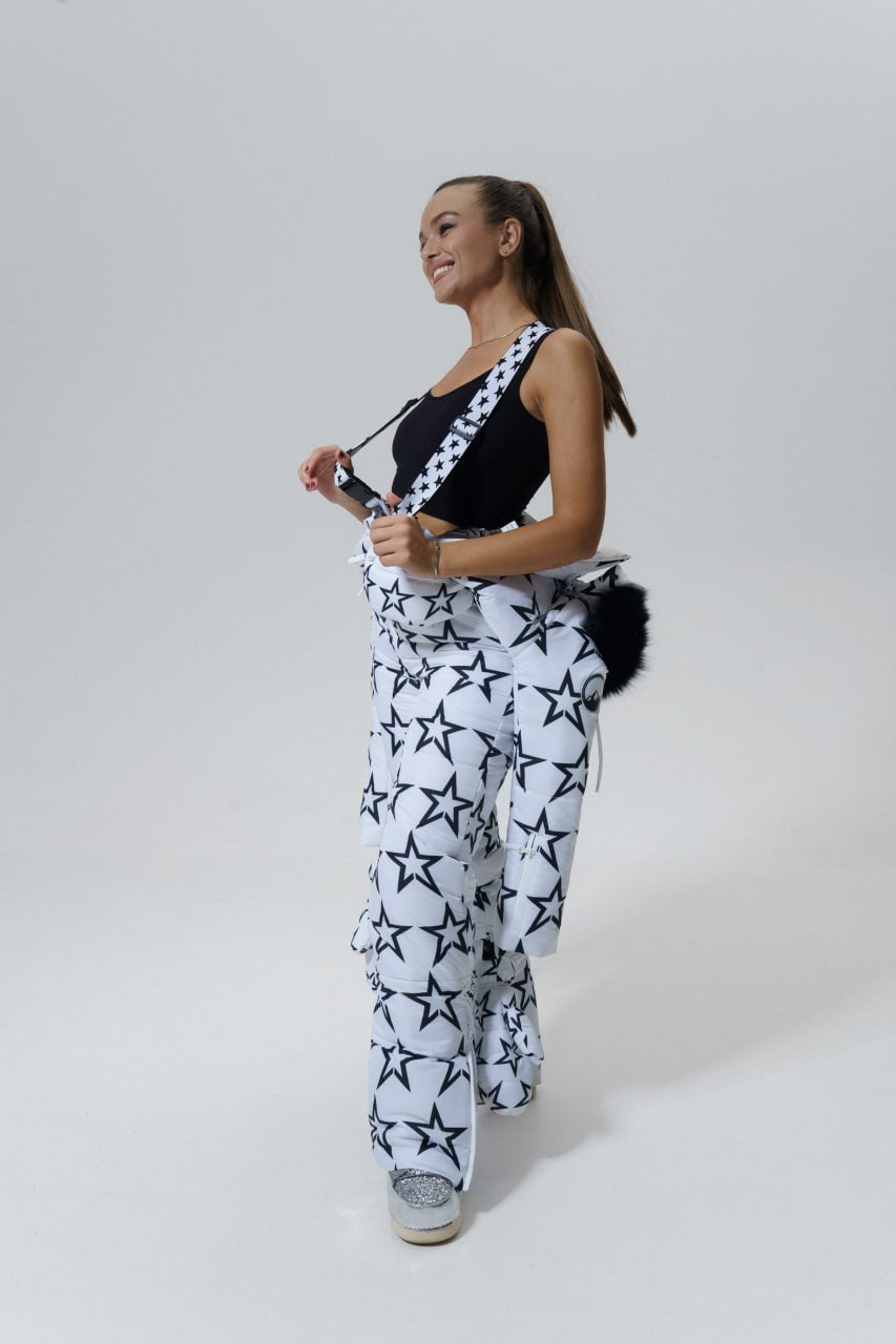 Woman wearing a black and white star-patterned outfit on a plain background