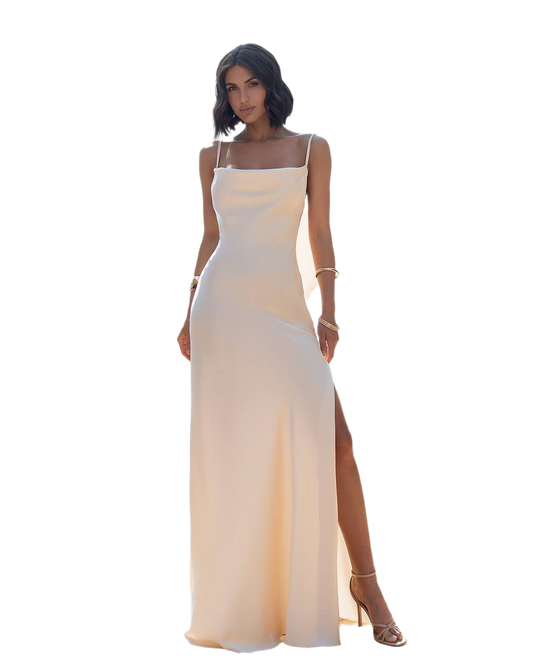 Woman wearing a beige evening gown with a slit on a white background