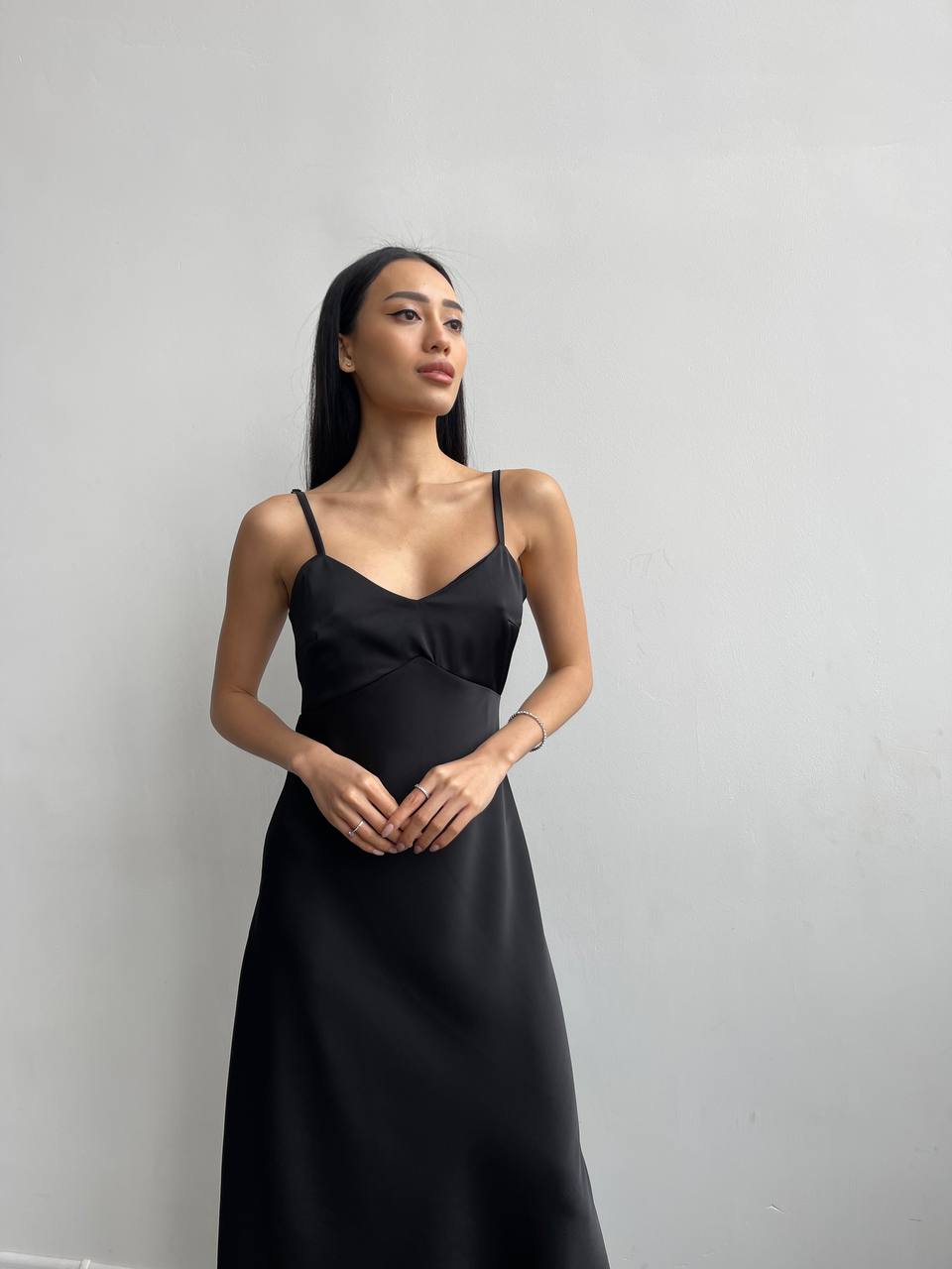 Woman wearing a black dress against a plain background