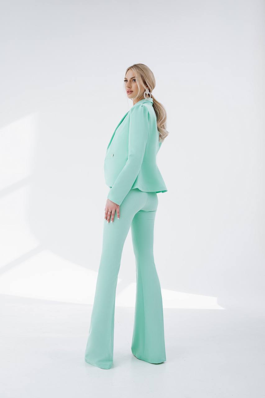 Woman wearing a mint green suit on a white background