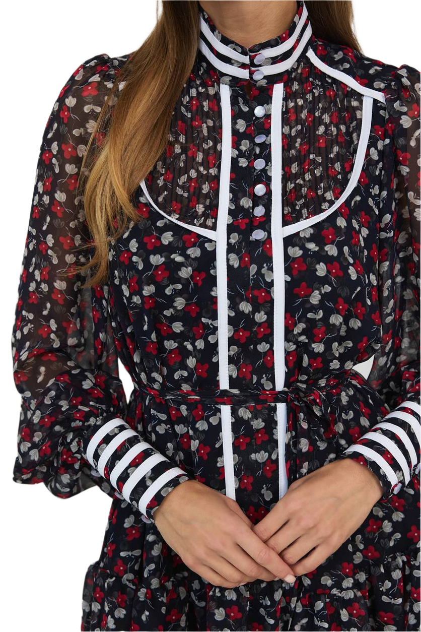 Woman wearing a floral dress with black, red, and white pattern