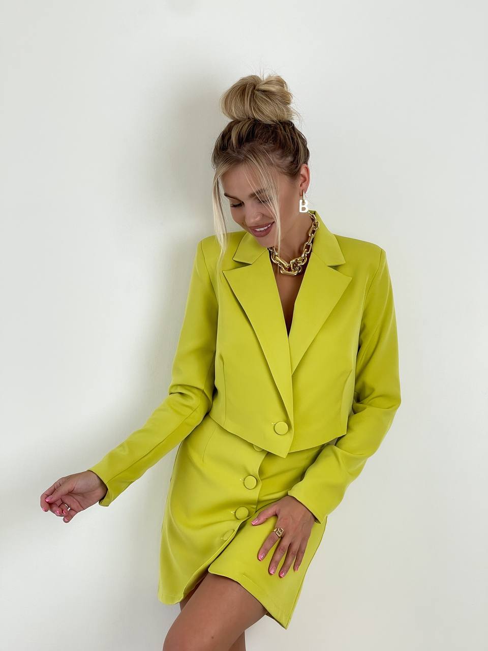 Woman wearing a bright yellow suit against a white background
