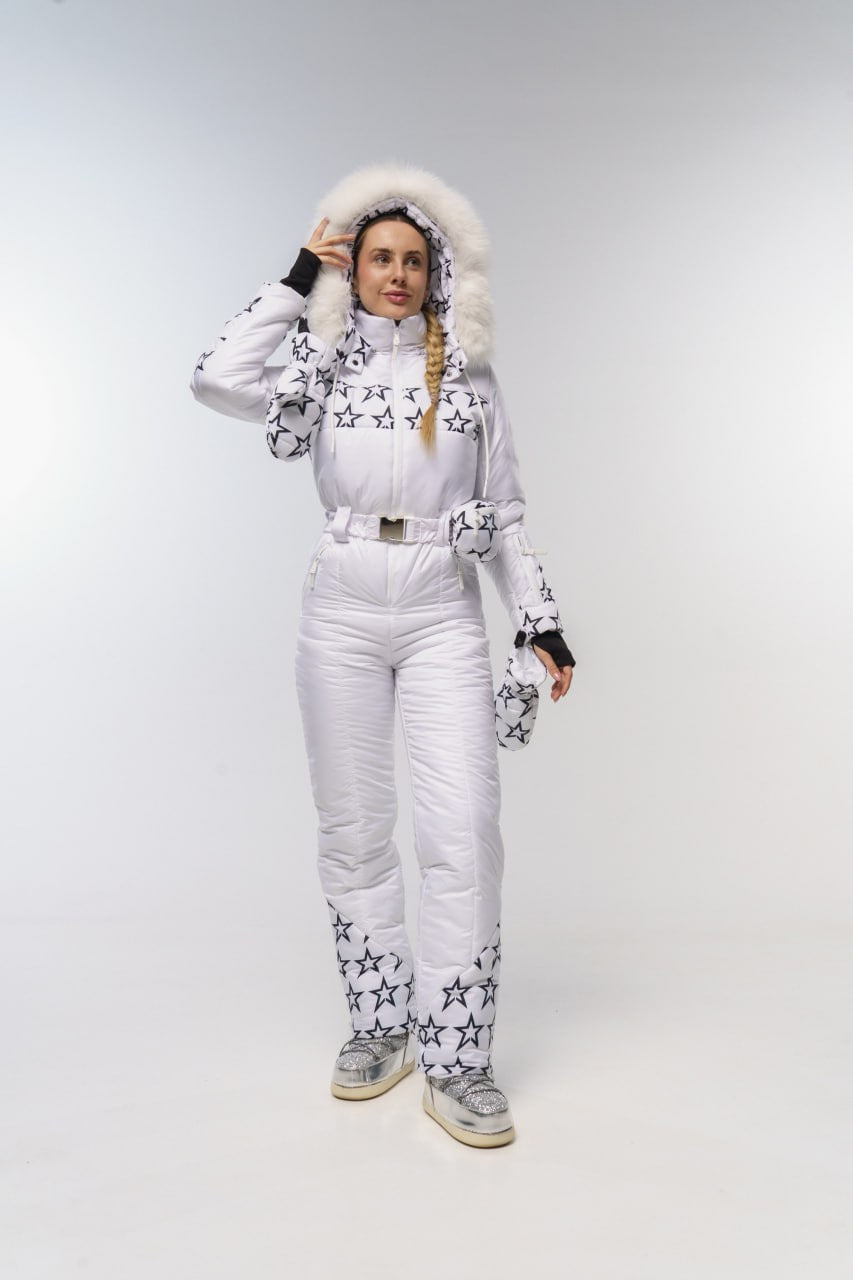 Person wearing a white snowsuit with star patterns on a plain background
