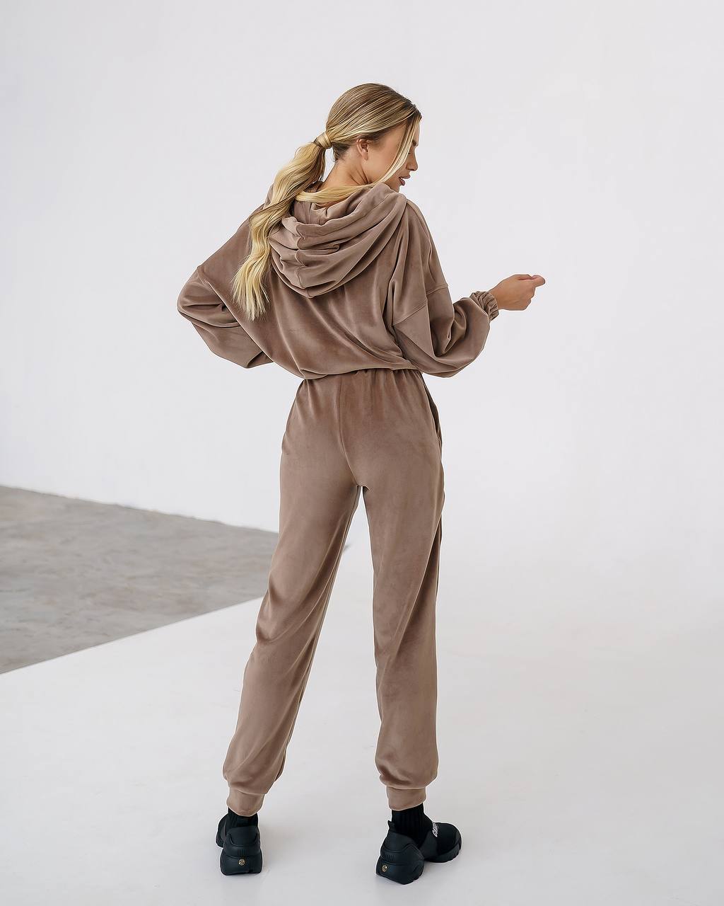 Woman wearing a brown tracksuit on a white background