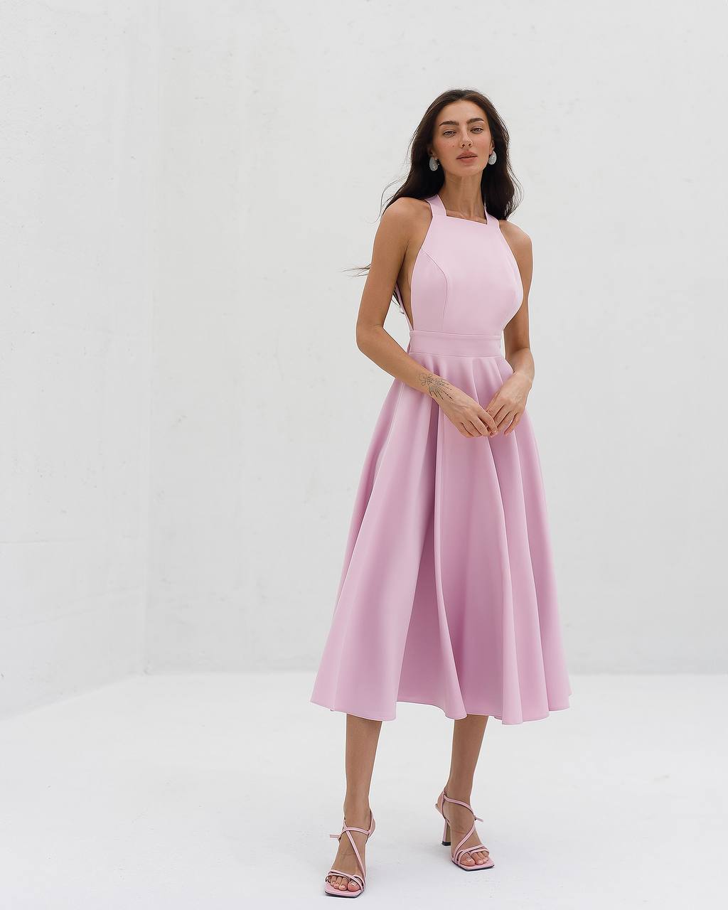 Woman wearing a pink dress against a white background