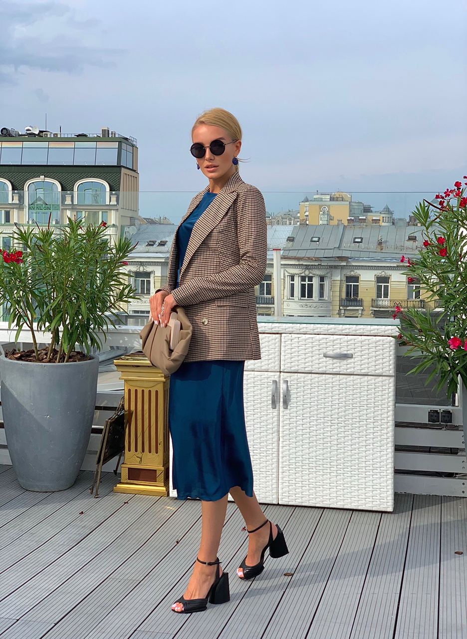 Woman in stylish outfit on a rooftop with cityscape background