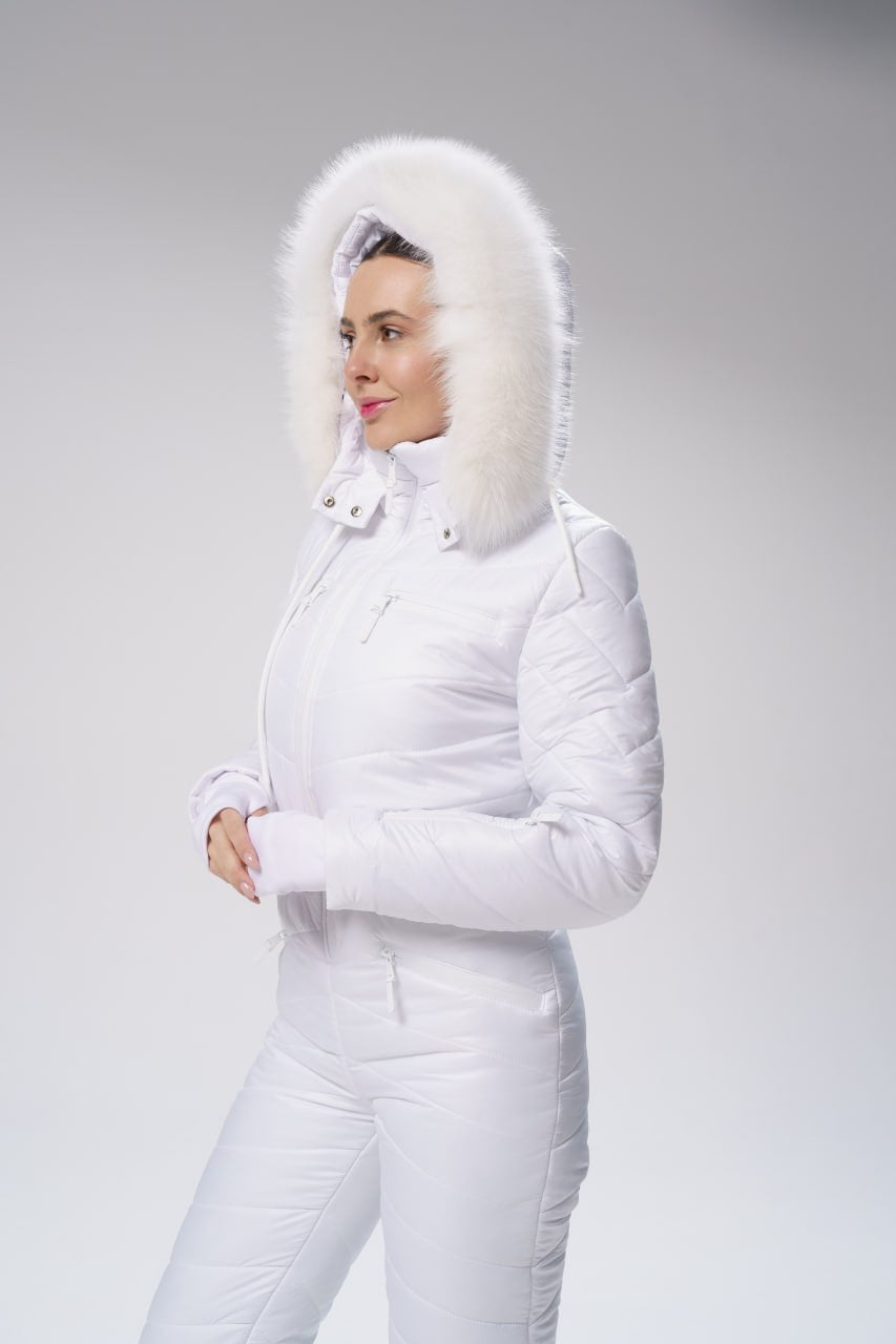 Person wearing a white winter outfit with a fur-lined hood on a gray background