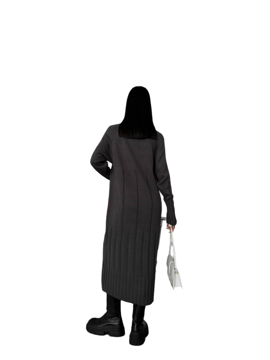 Person wearing a long dark coat holding a white bag on a white background
