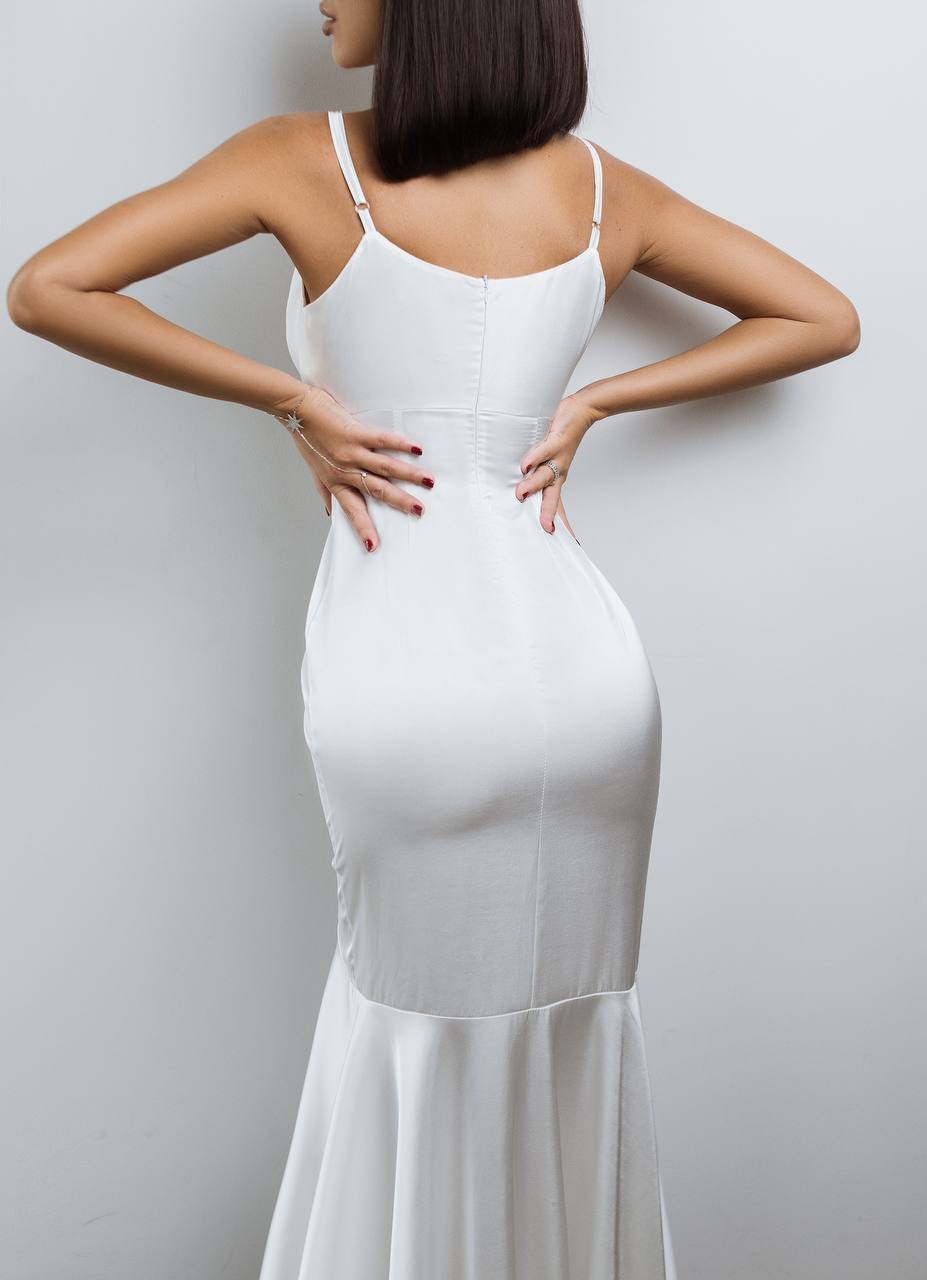 Woman wearing a white dress against a plain background