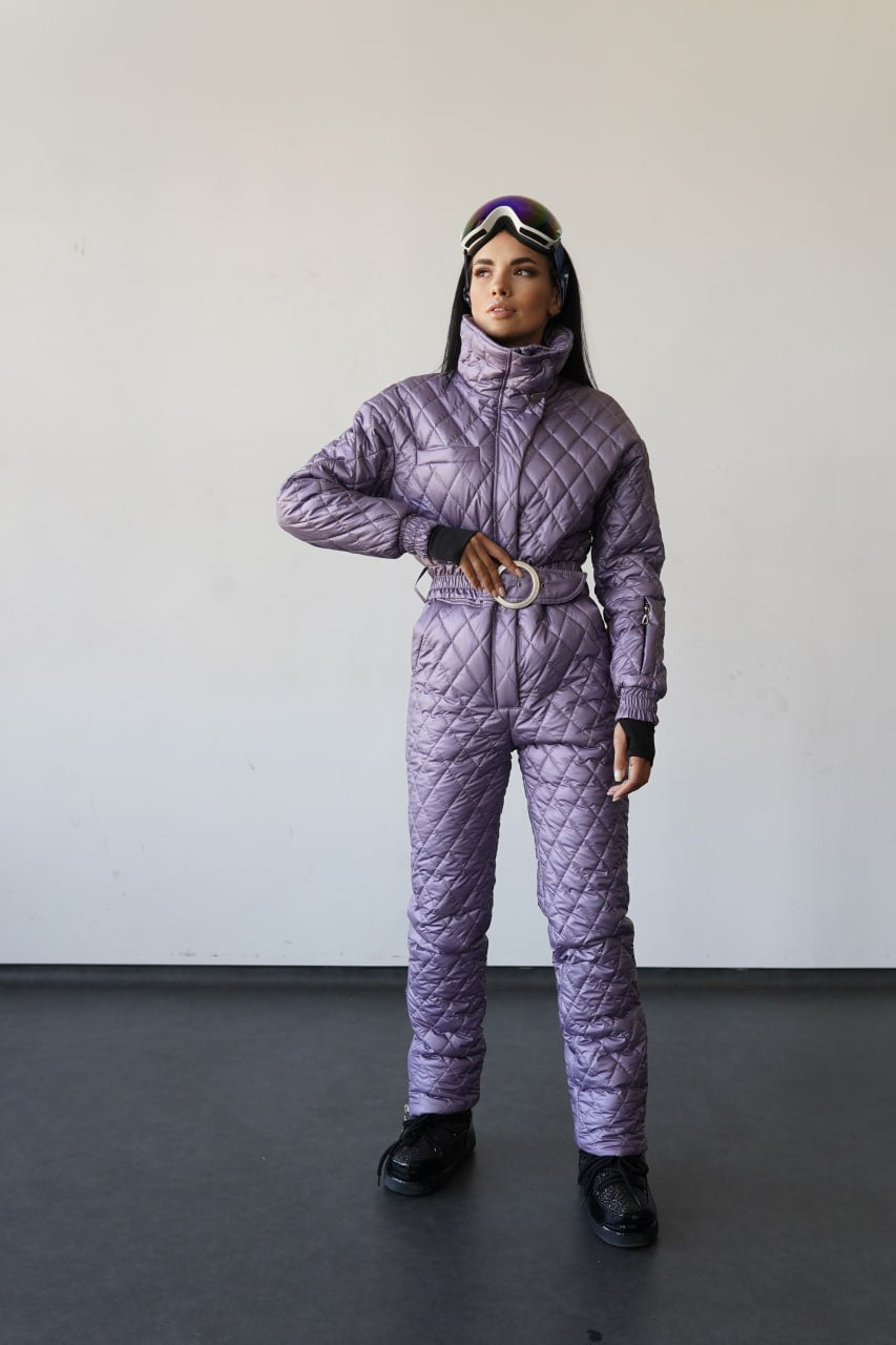 Person wearing a purple quilted snowsuit against a plain background