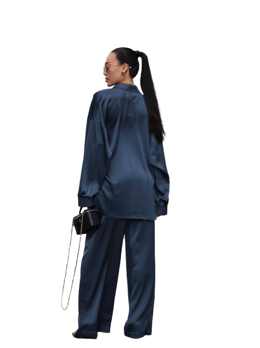 Person wearing a blue satin outfit with a white background