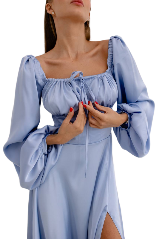 Woman wearing a light blue dress with long sleeves on a white background