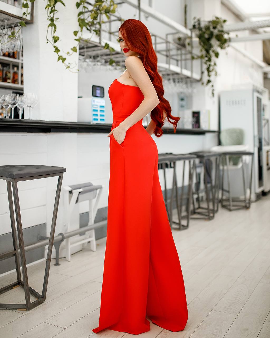 Woman in a red dress standing in a modern indoor setting