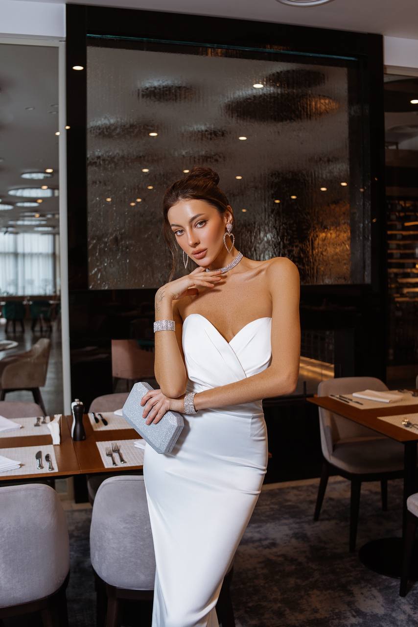 Woman in a white dress standing in a restaurant setting