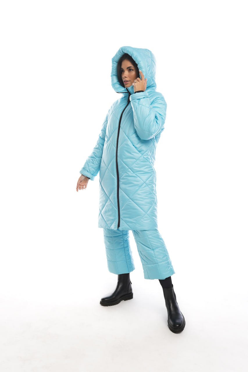 Person wearing a light blue quilted jumpsuit on a white background