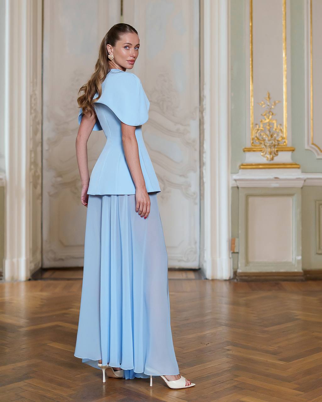 Woman wearing a light blue dress in an elegant interior setting
