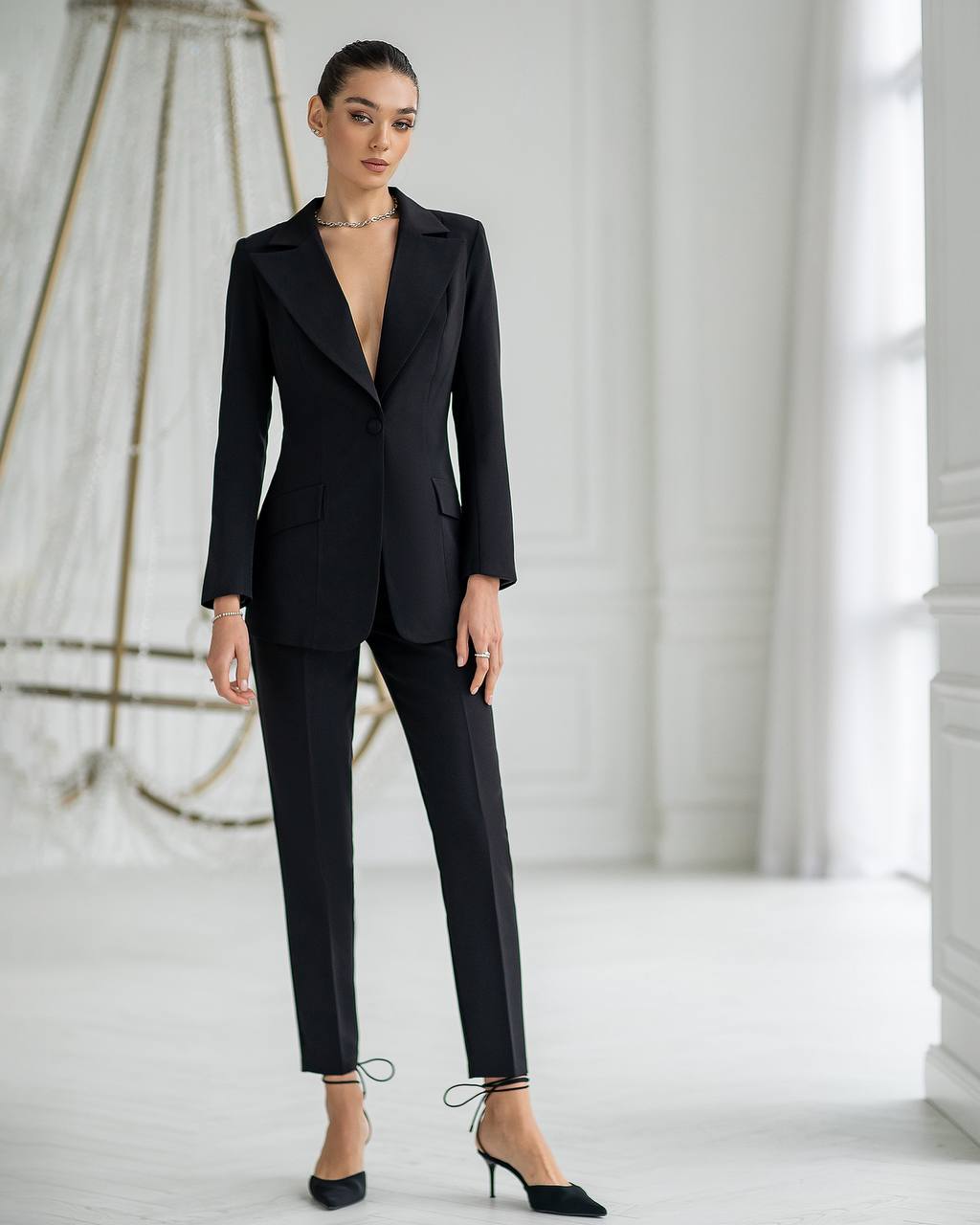 Woman wearing a black suit in a minimalistic setting