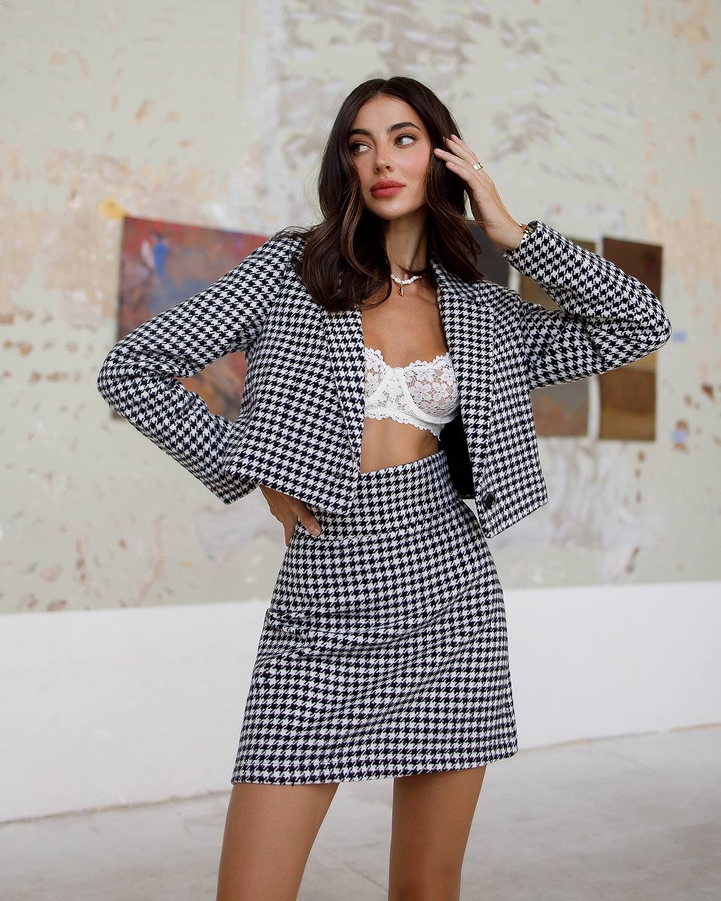 Woman wearing a black and white checkered outfit in an indoor setting.