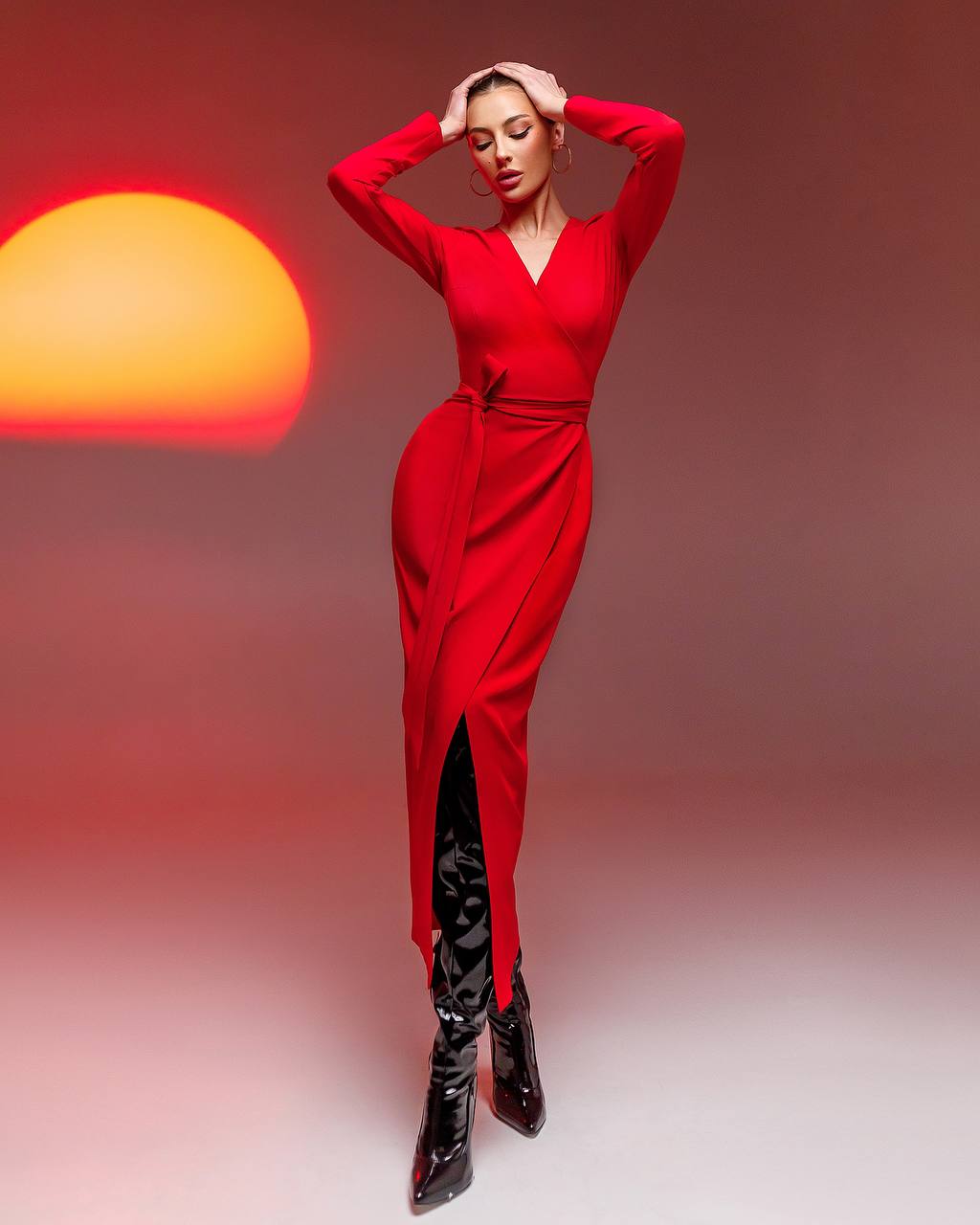 Woman in a red dress with a blurred warm light in the background