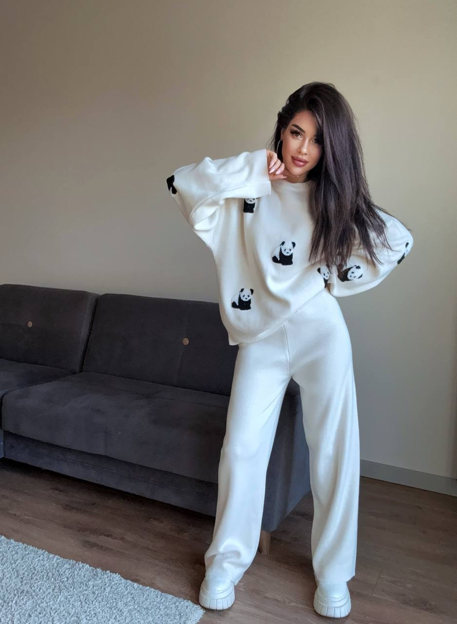 Person wearing a white outfit with panda designs in a living room.