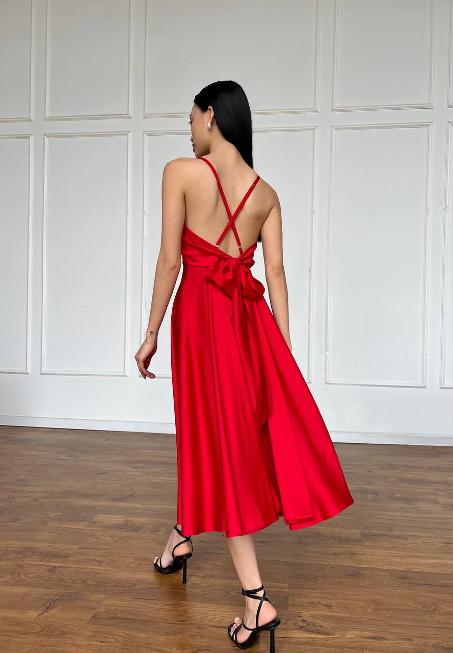 Woman wearing a red dress with a white paneled wall background