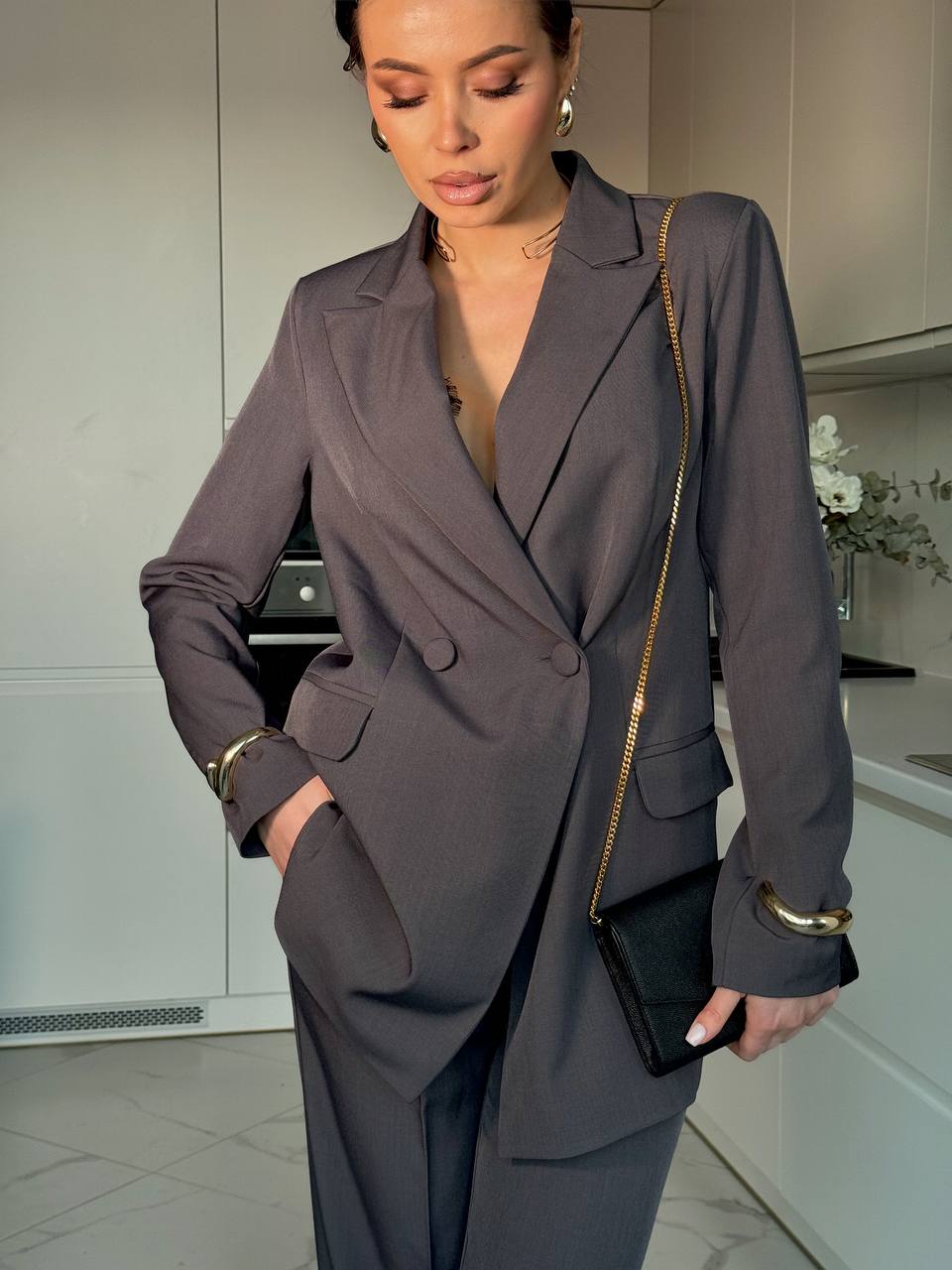 Woman in a gray suit standing in a kitchen