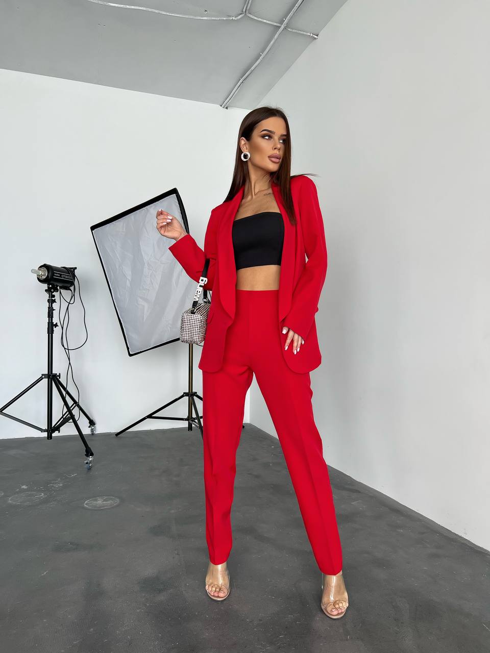 Woman in a red suit standing in a studio setting