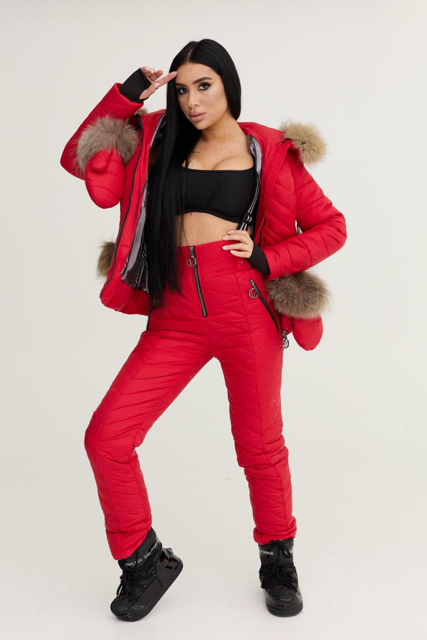 Person wearing a red snowsuit with fur-lined hood on a white background